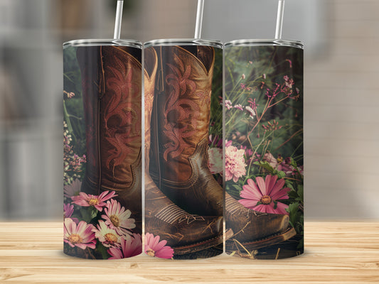 Brown leather cowboy boots with pink stitching, surrounded by flowers.
