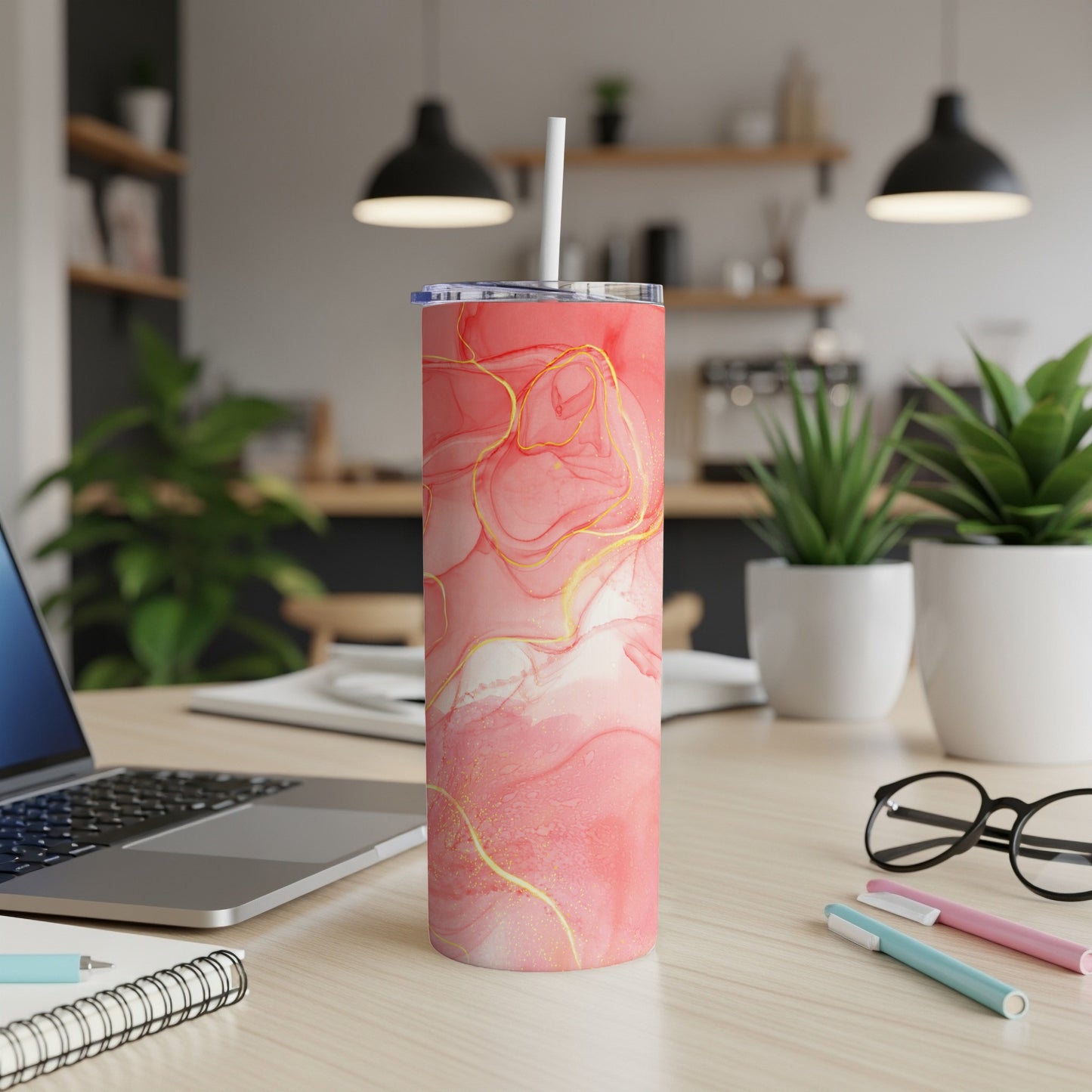 Pink and gold abstract marble pattern skinny tumbler with white straw.