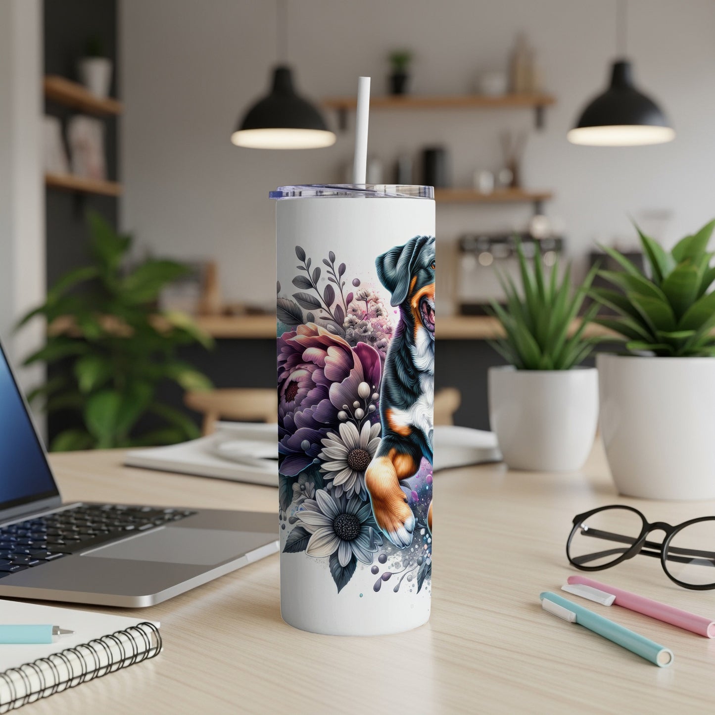 Dog and floral design on white tumbler with straw on desk.