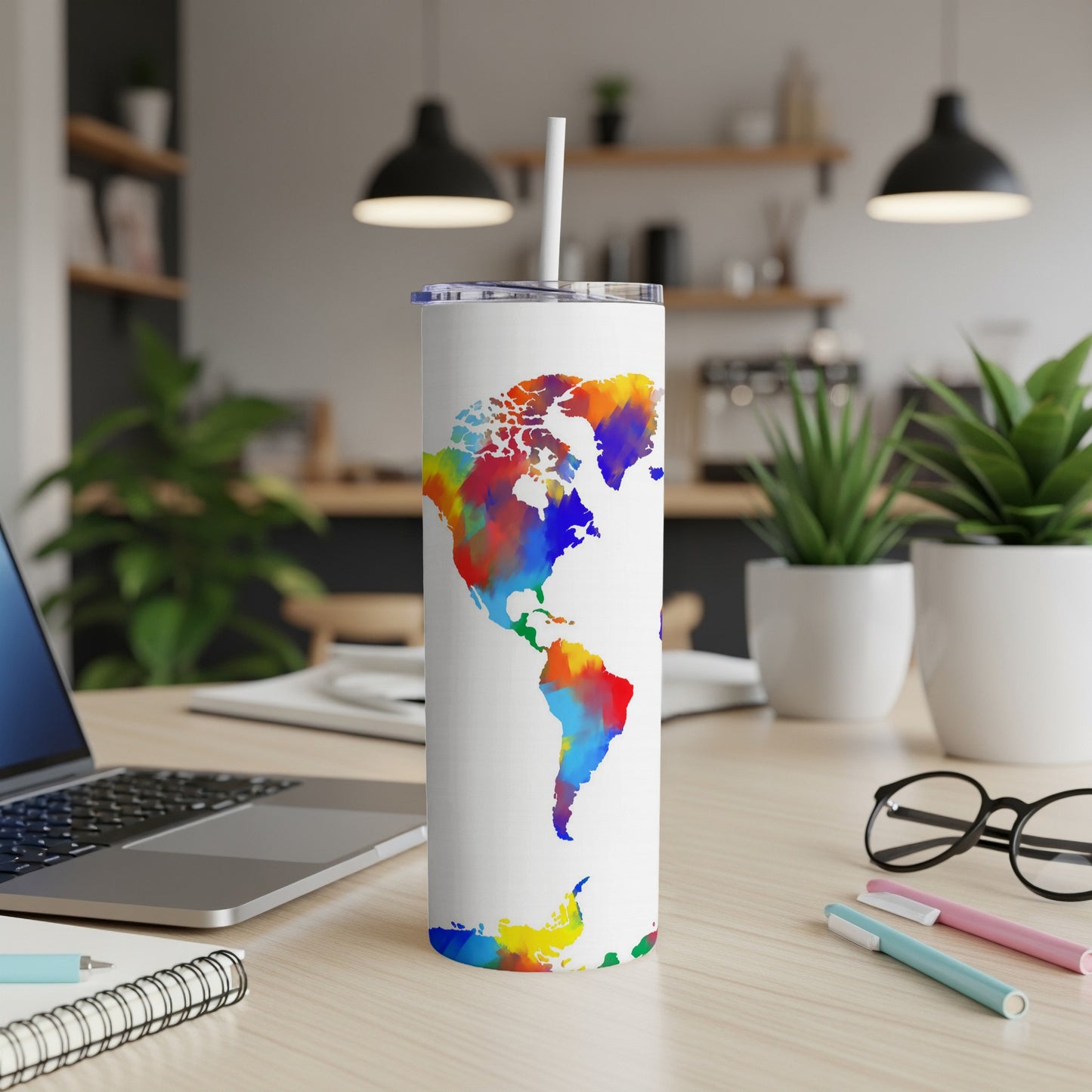 White tumbler with a colorful watercolor world map design and a straw.