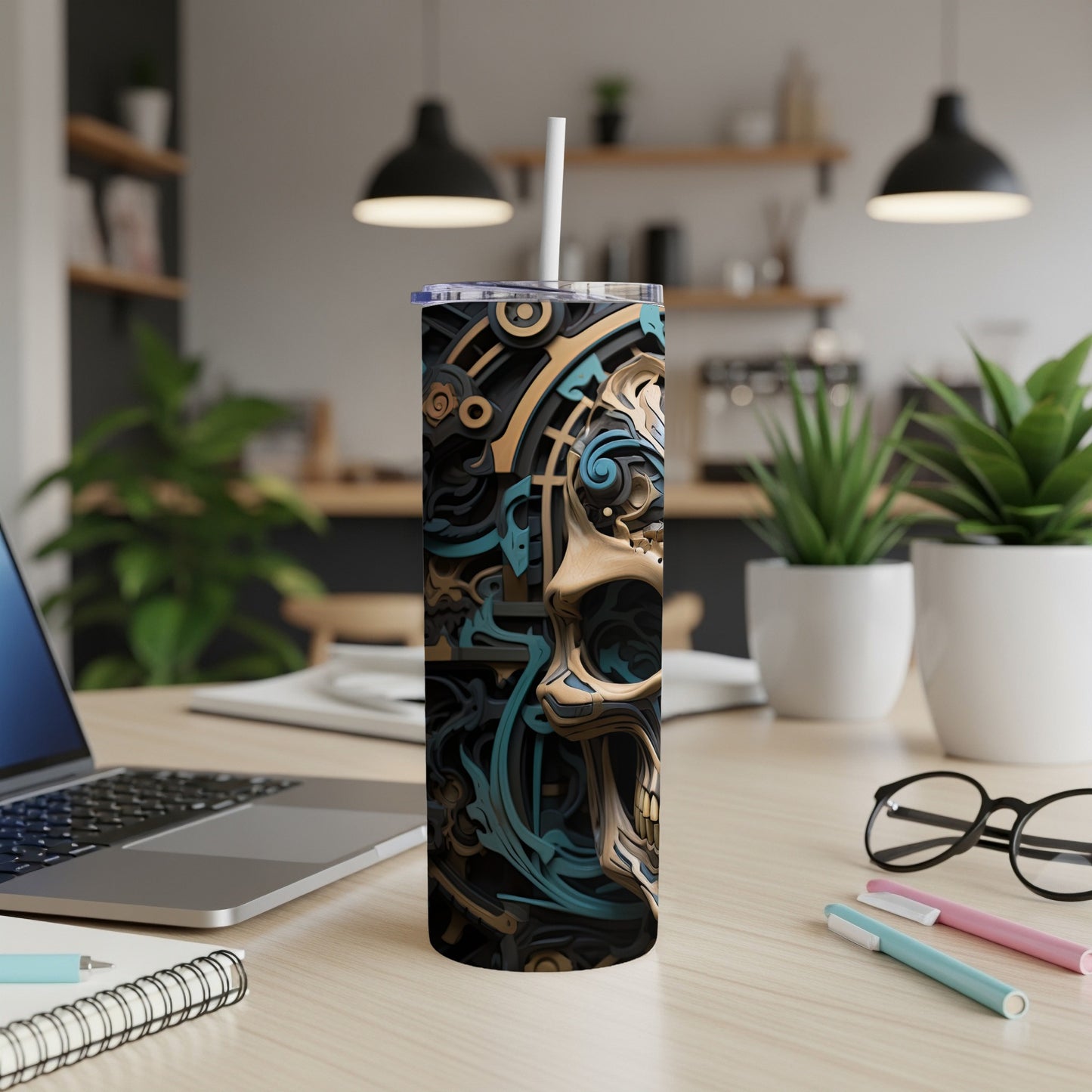 Tumbler with a black, gold, and teal abstract skull design.