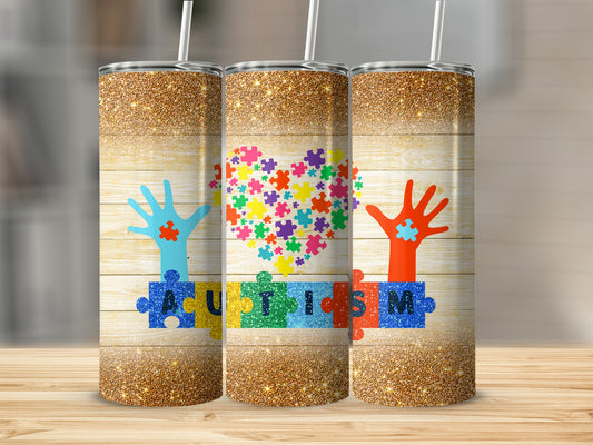 Three tumblers with a wooden background, autism puzzle pieces, and hands.