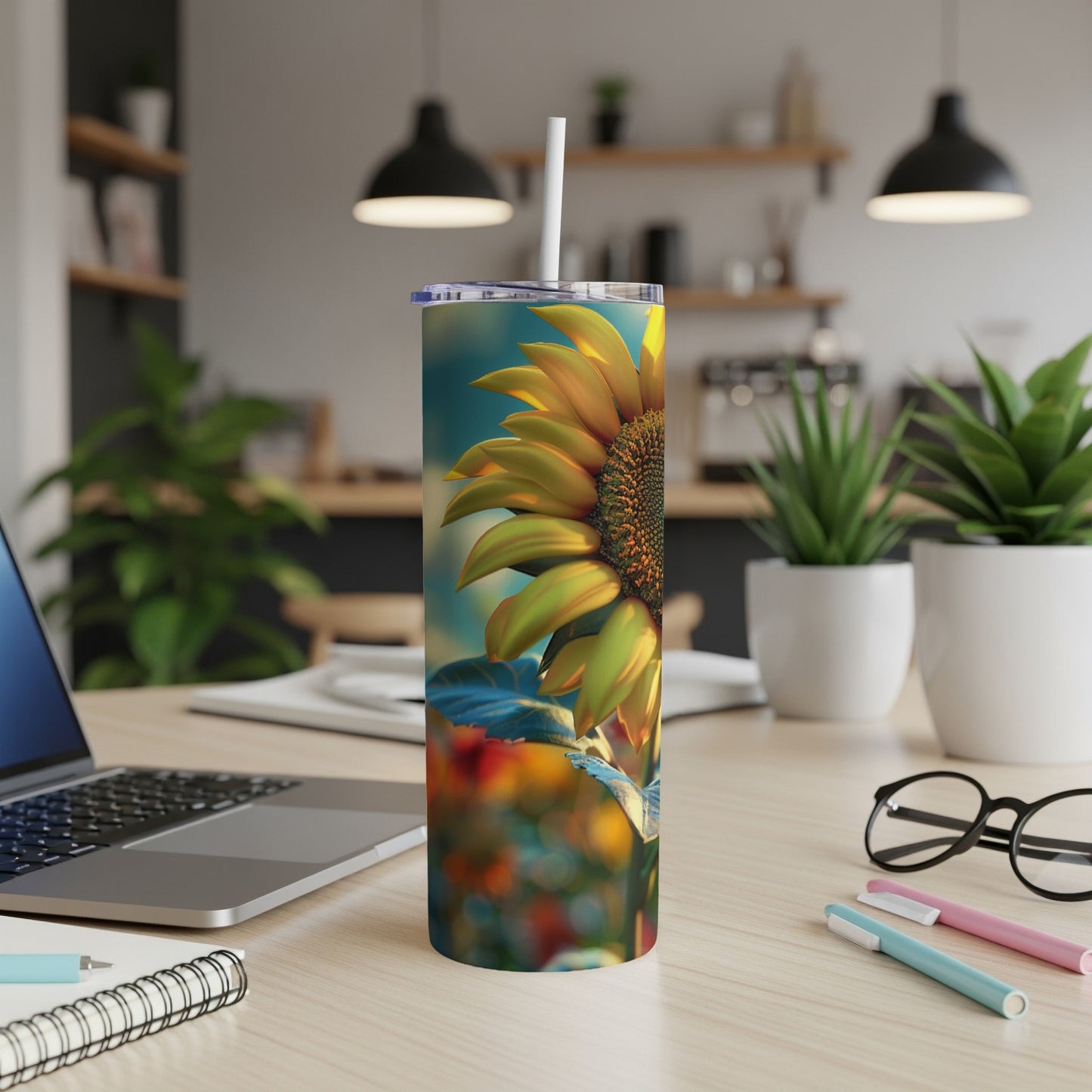 Sunflower tumbler with straw on a desk.