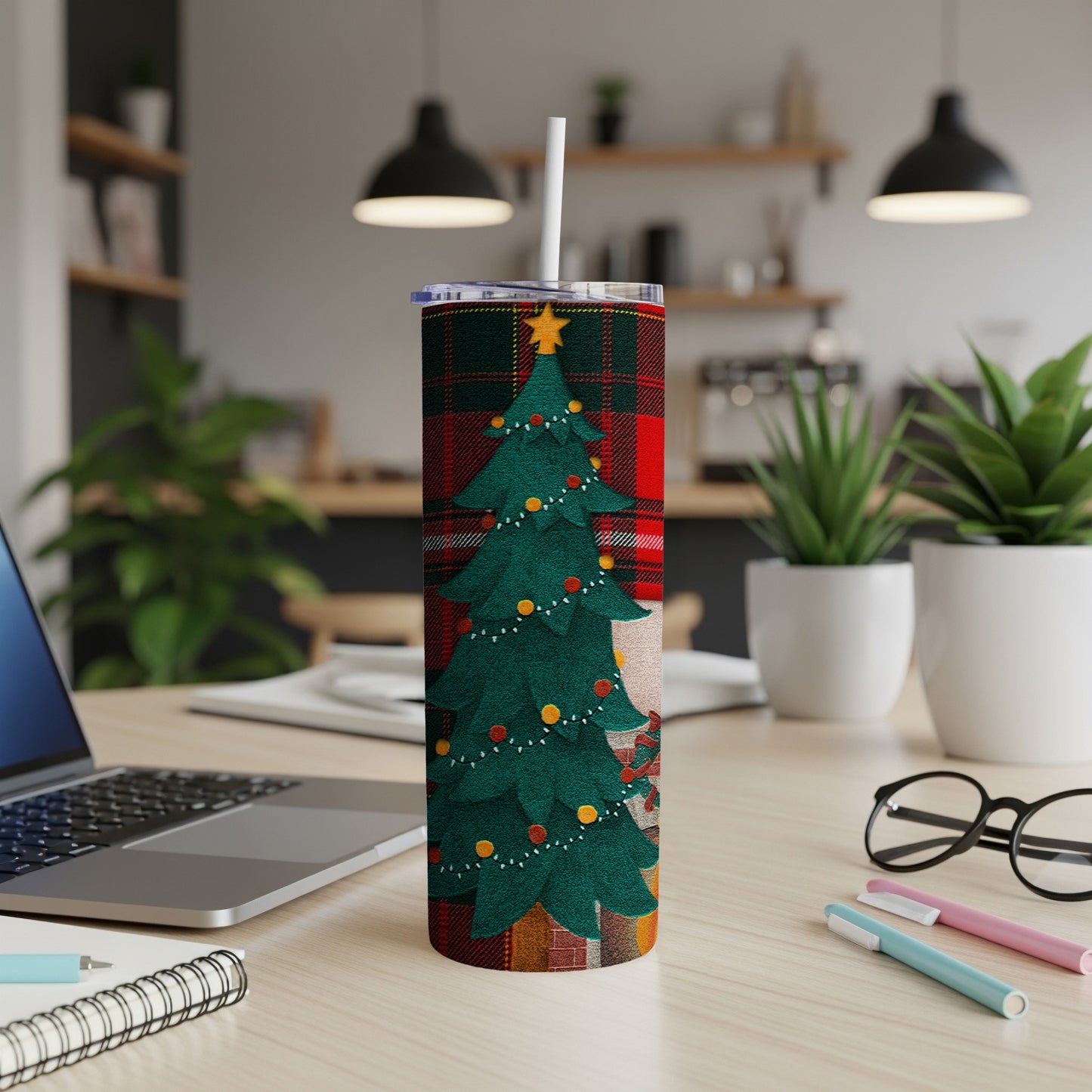 Festive Christmas tumbler with plaid pattern and tree design on a desk.