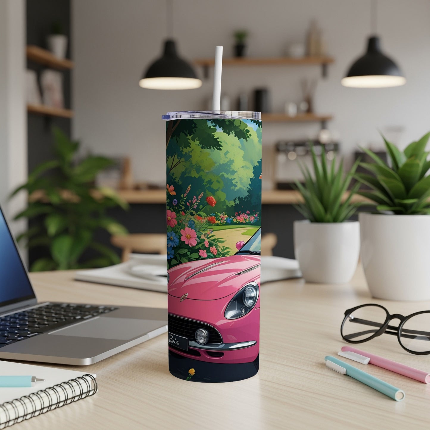Pink car and flowers on a tumbler with a laptop and office supplies.