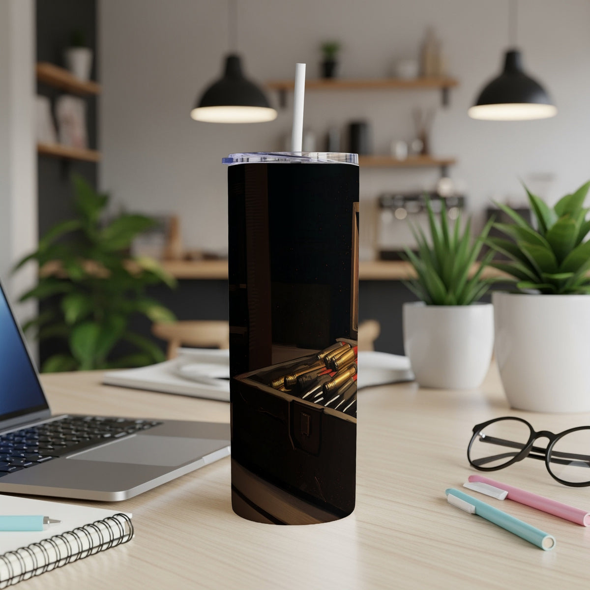 Tumbler with a bullet pattern design on a desk with a laptop and plants.