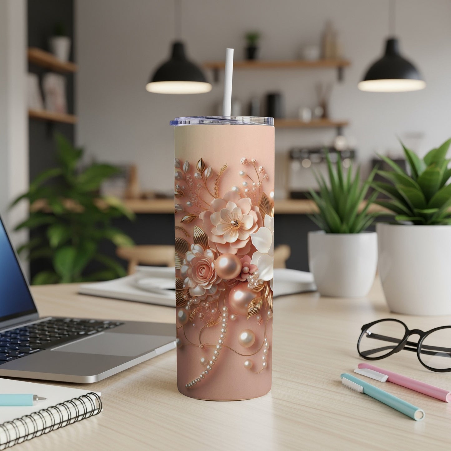 Pink floral tumbler with pearls and gold accents on a desk.