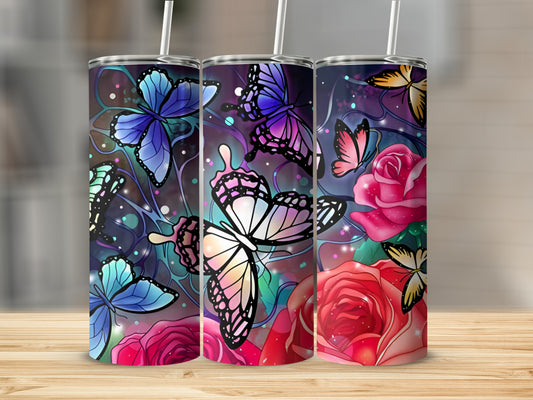 Three tumblers with colorful butterflies and roses, on a wooden surface.