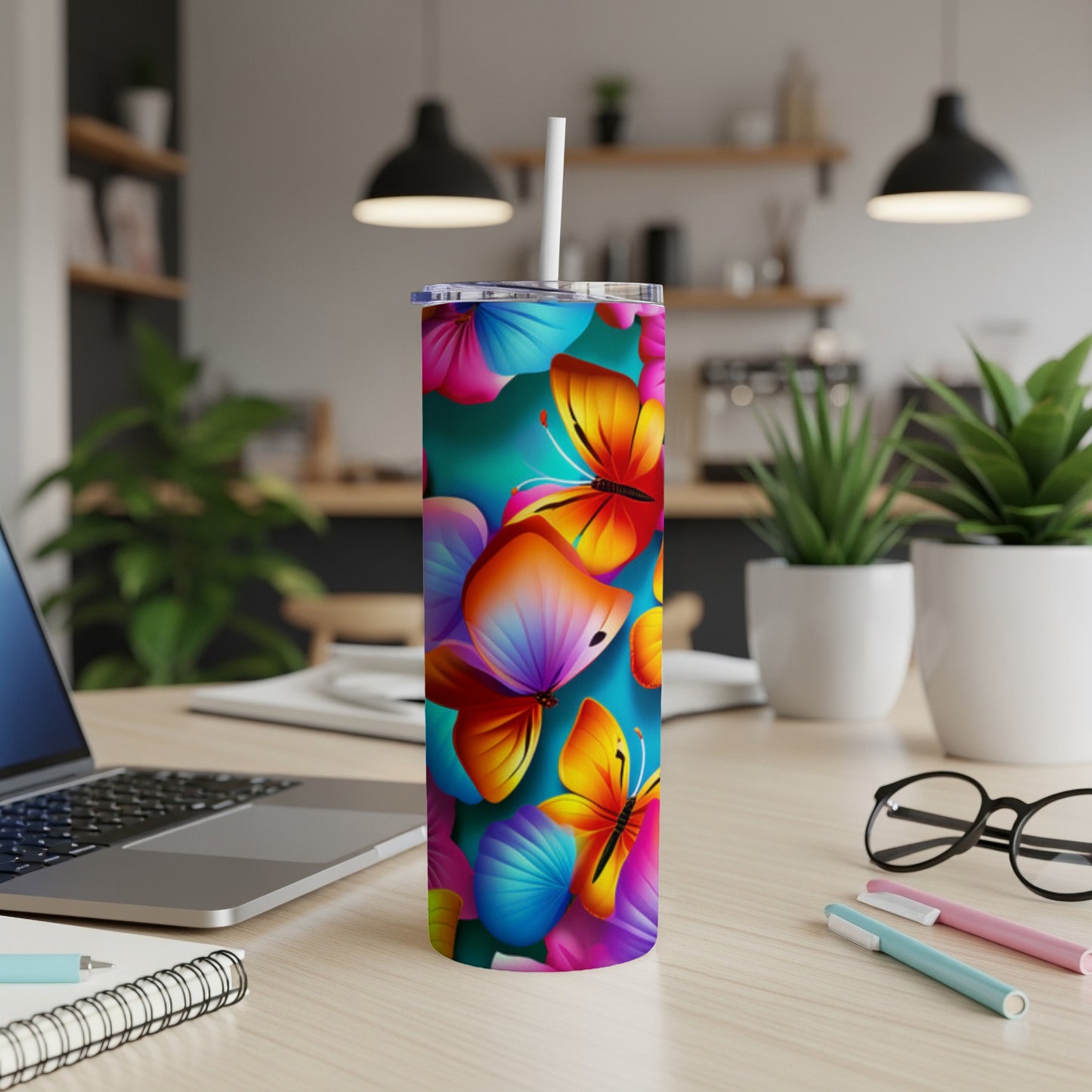 Tumbler with colorful butterflies on a teal background.