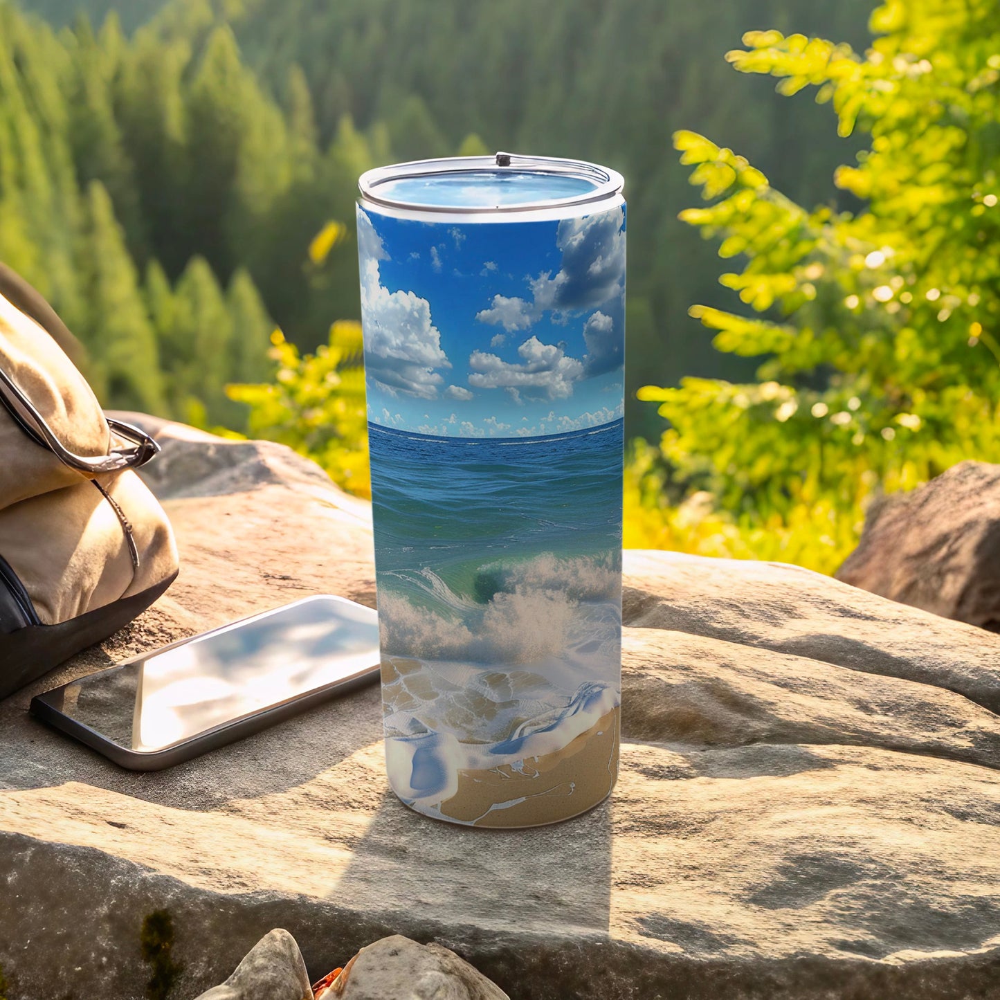Tall tumbler with a beach and ocean wave design on a rock.