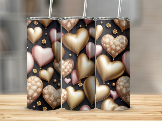 Three tumblers with gold and pink heart pattern on dark background.