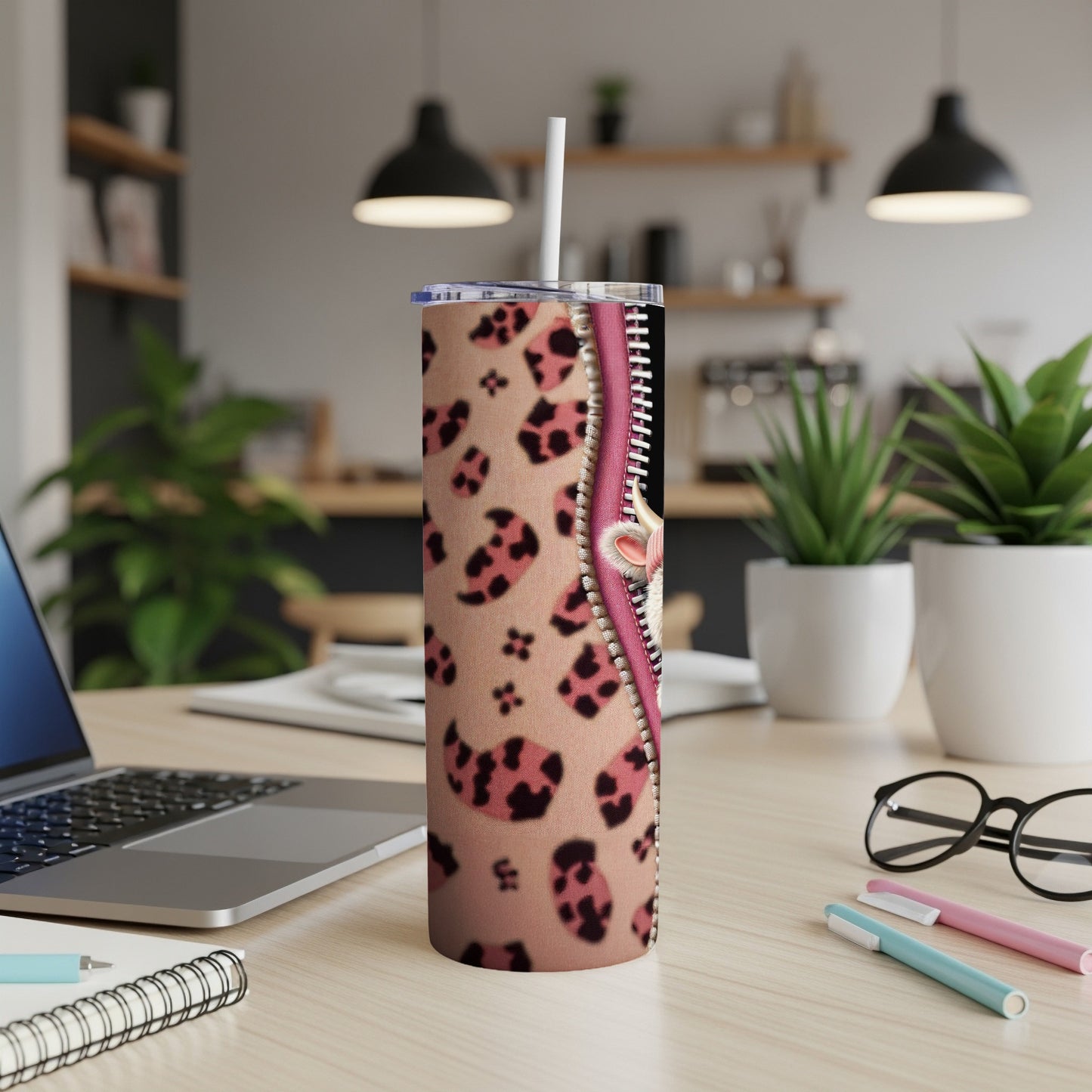 Pink leopard print tumbler with a zipper detail and a straw.