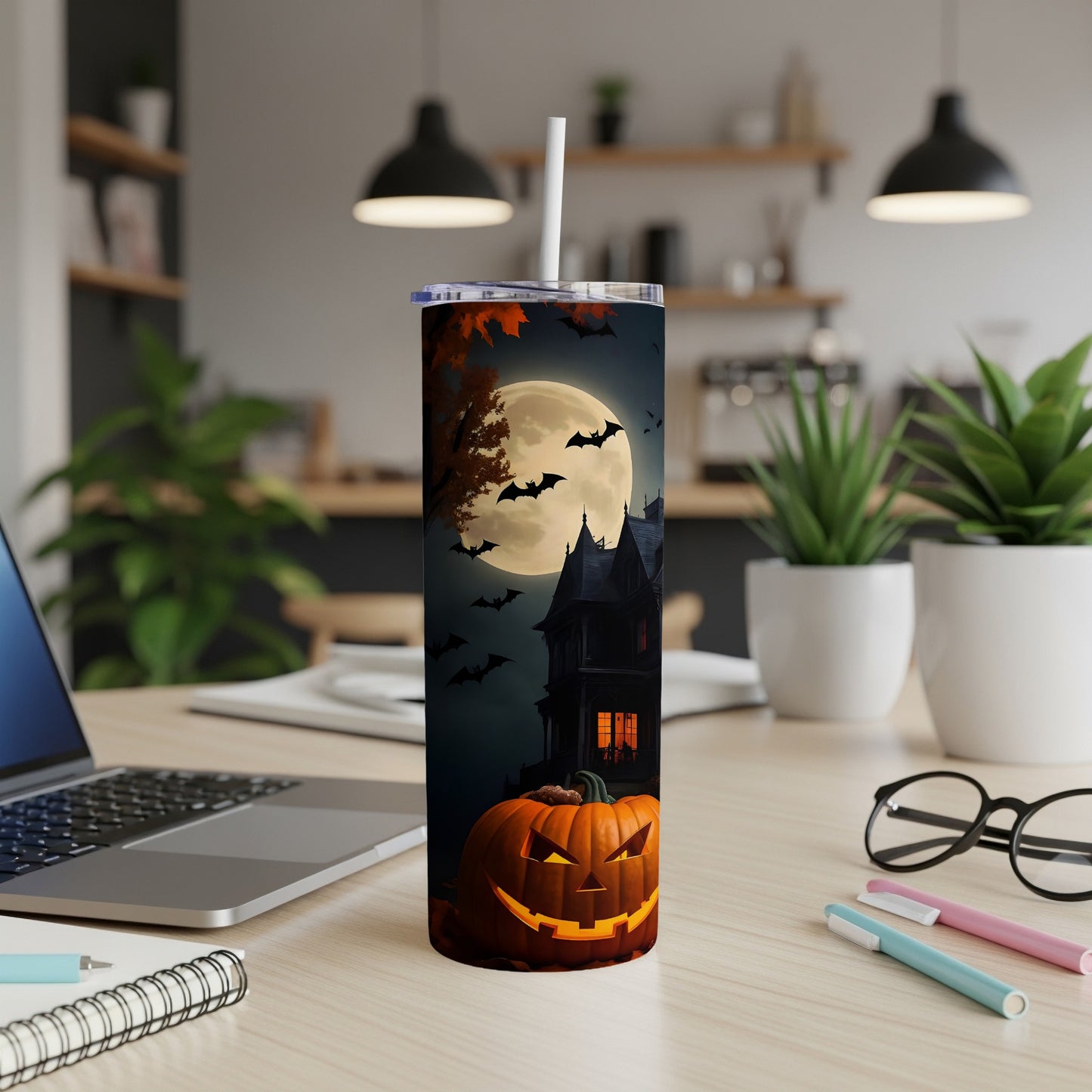 Tall tumbler with Halloween design featuring a haunted house, full moon, bats, and a jack-o'-lantern.