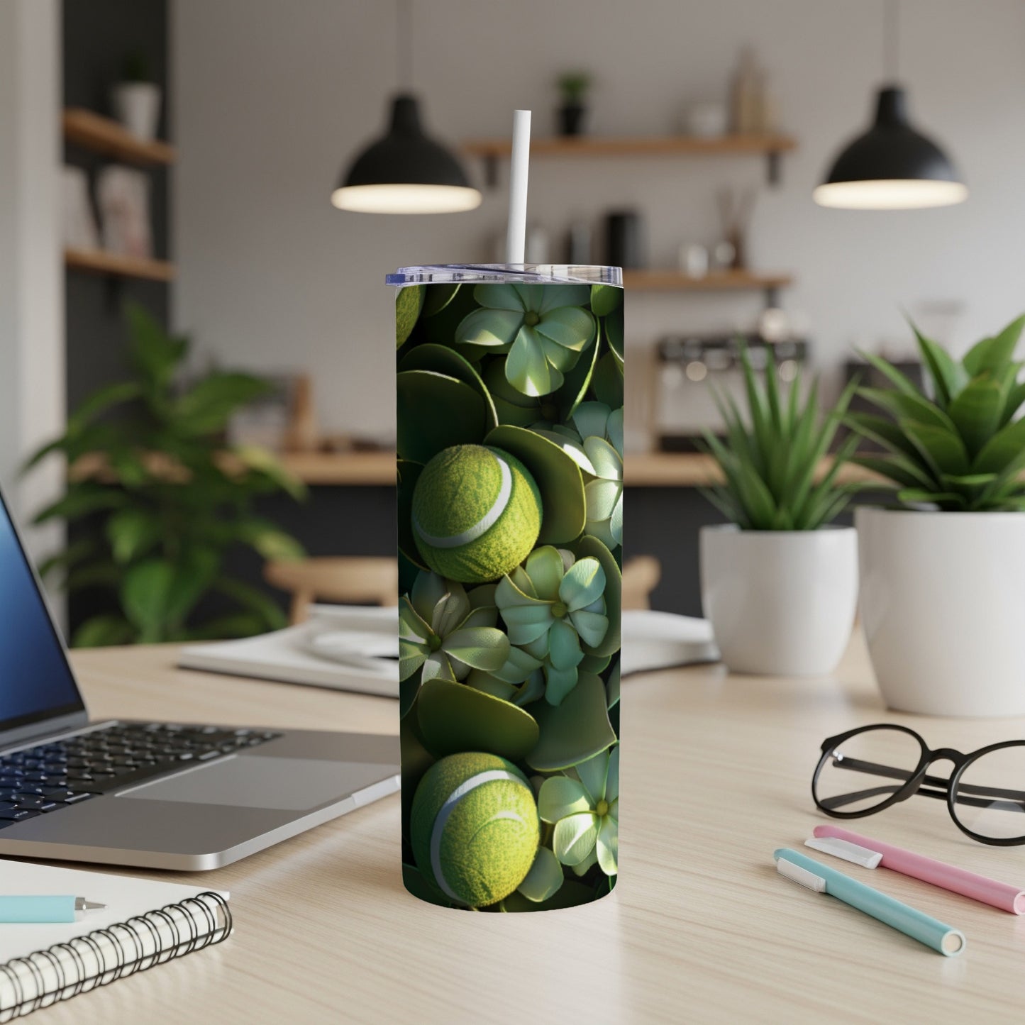 Tennis balls and green leaves pattern on a tumbler with a straw.