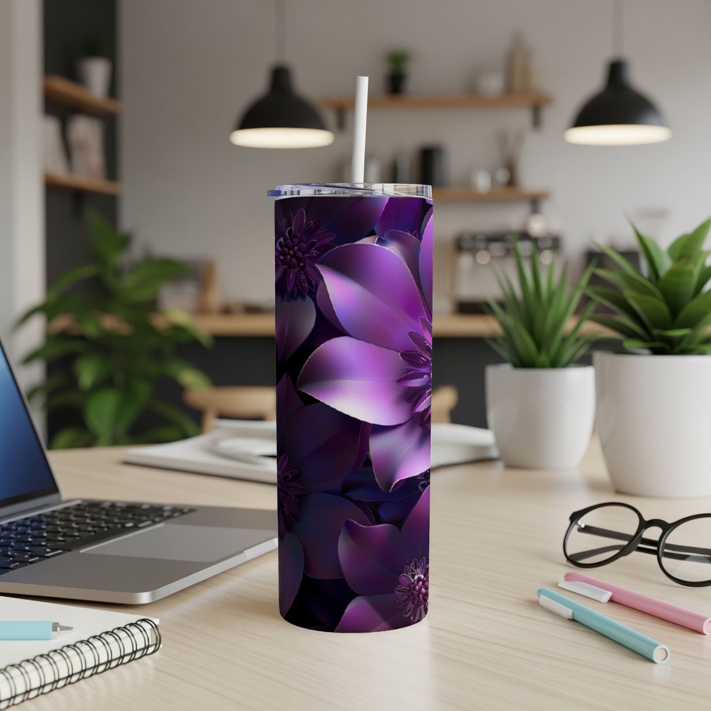 Purple floral patterned tumbler with straw on a desk.