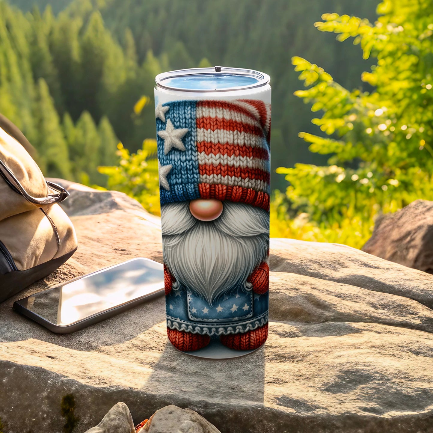 Gnome tumbler with US flag beanie and outfit, outdoors with phone and backpack.