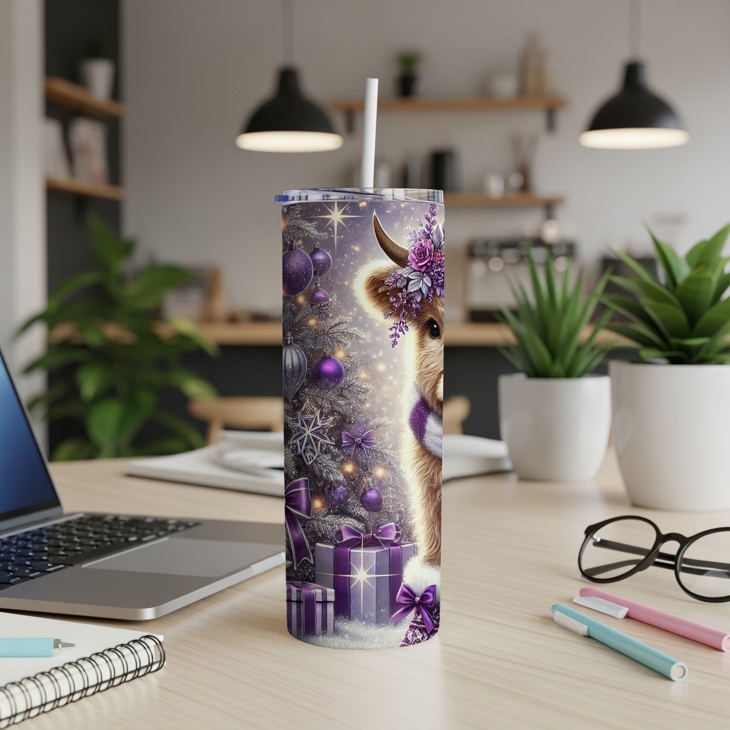 Purple Christmas cow tumbler with gifts and decorated tree on desk.