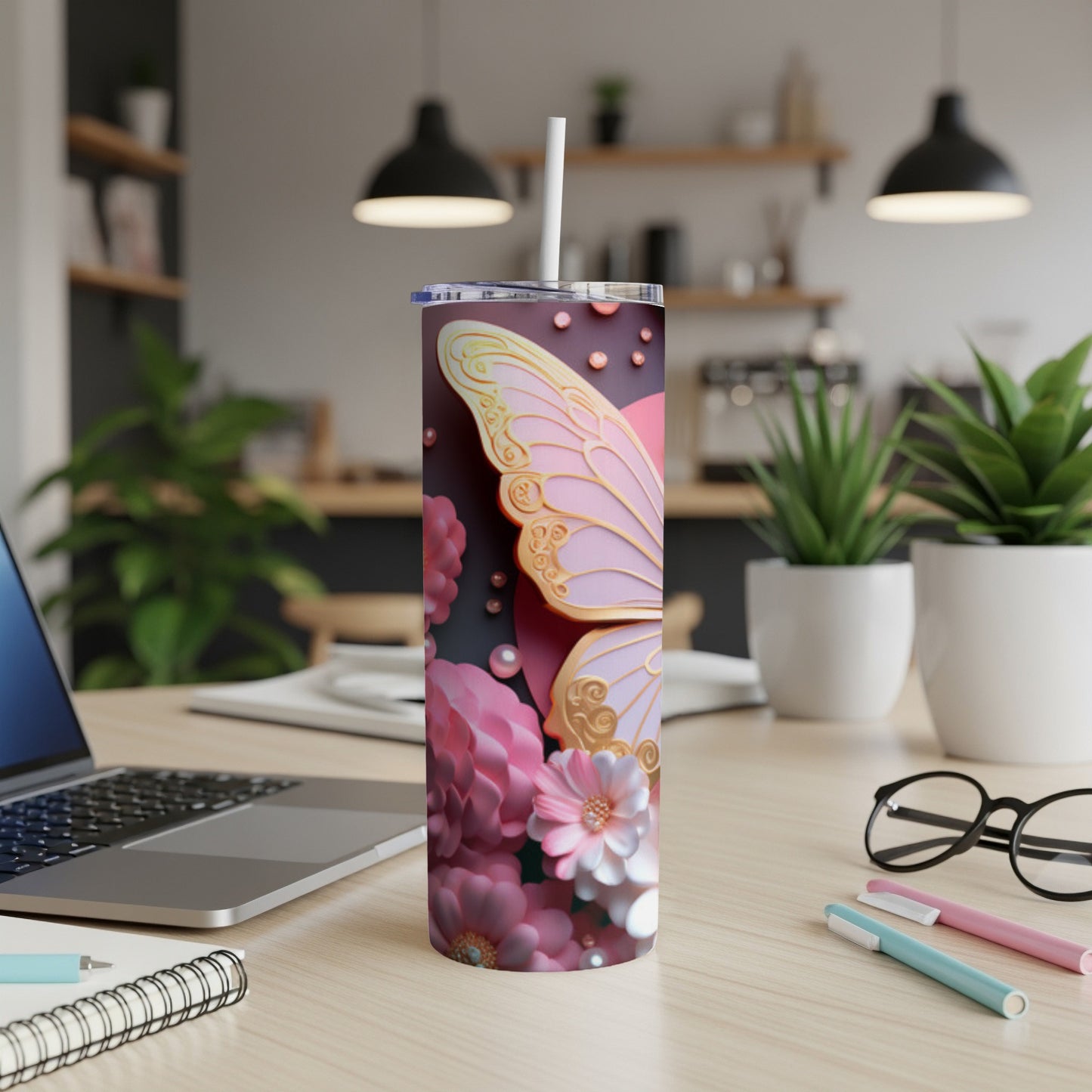 Pink butterfly wing design on a white tumbler with a straw.