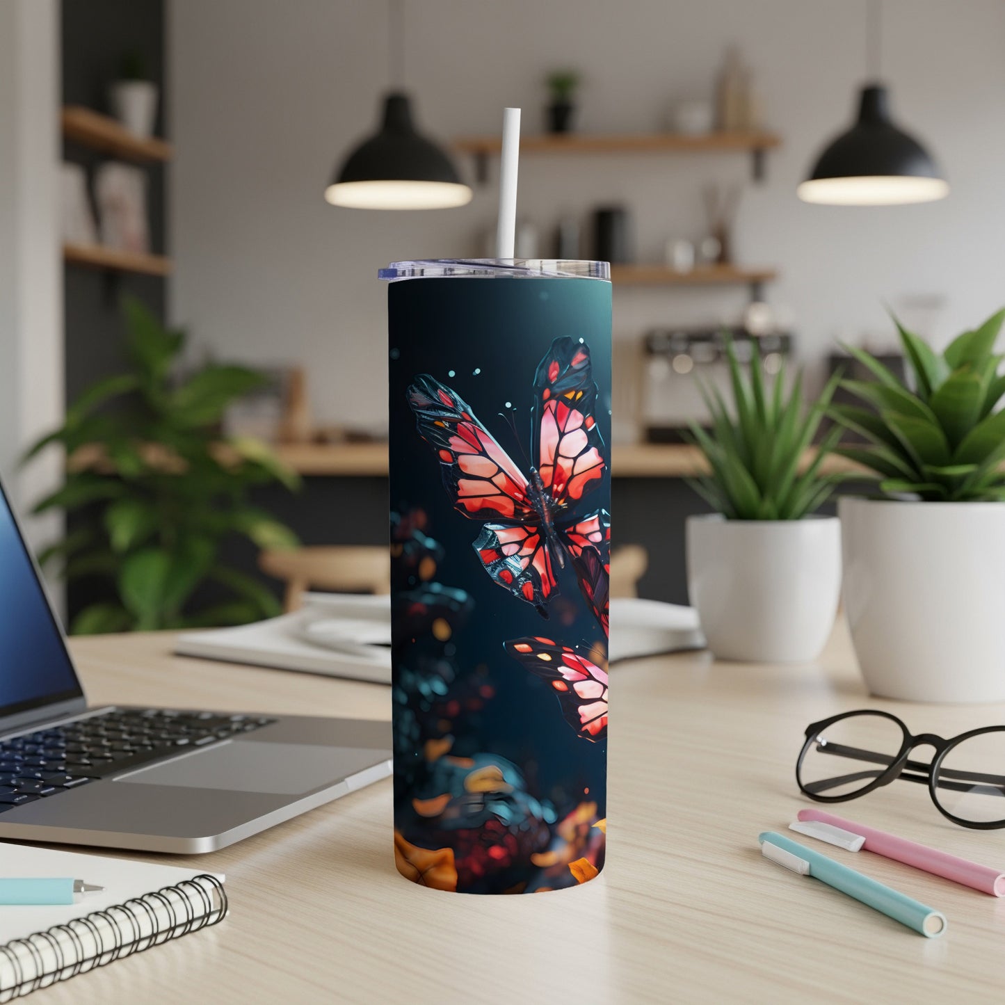 Tumbler with a colorful butterfly design and straw, on a desk.