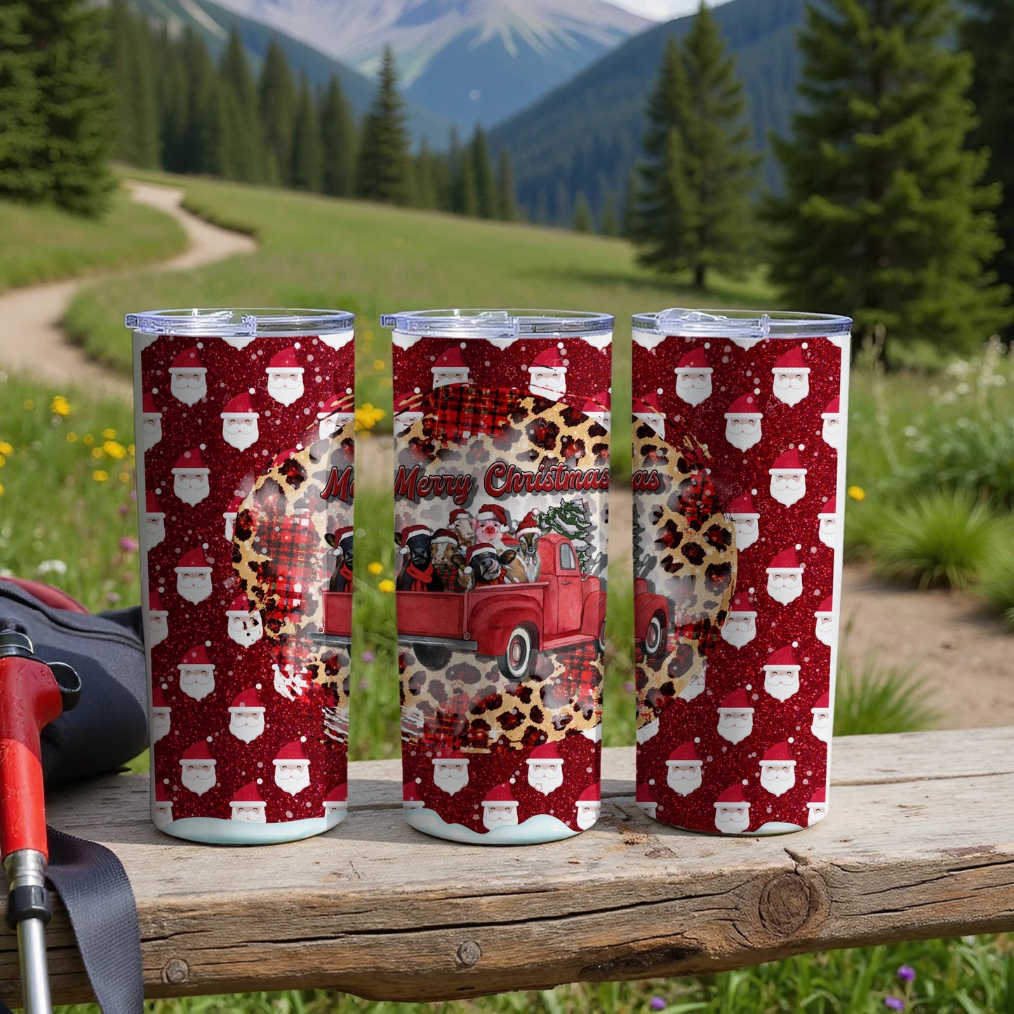 Three patterned tumblers with Santa Claus and Christmas motifs on a wooden surface.