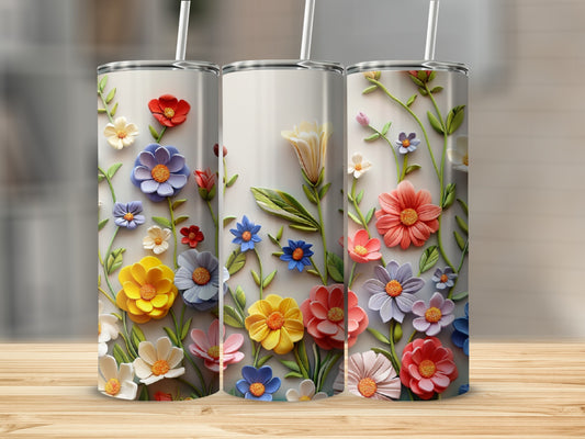Three tumblers decorated with colorful embossed wildflowers and leaves.