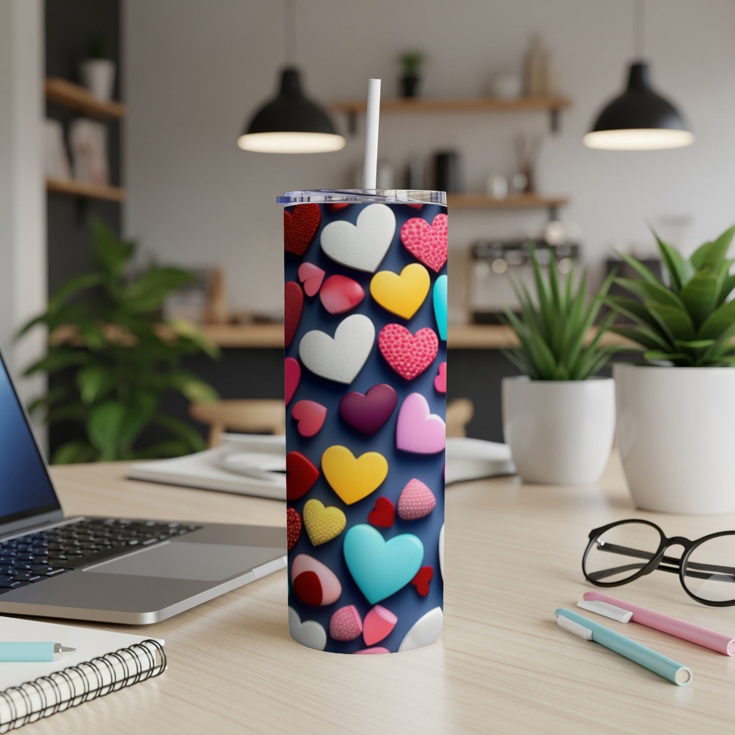 Tumbler with assorted colorful hearts pattern and straw on a desk.