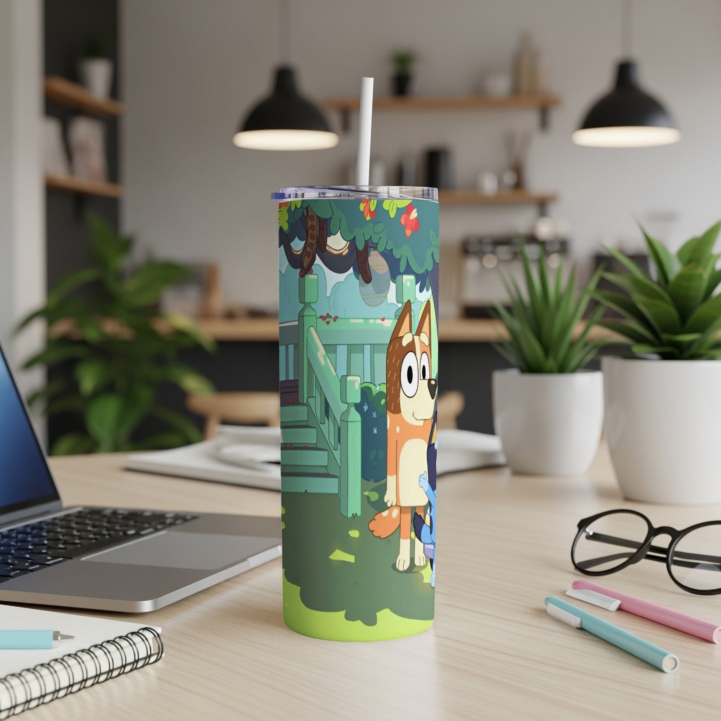 Bluey and Bingo characters on a green tumbler on a desk.