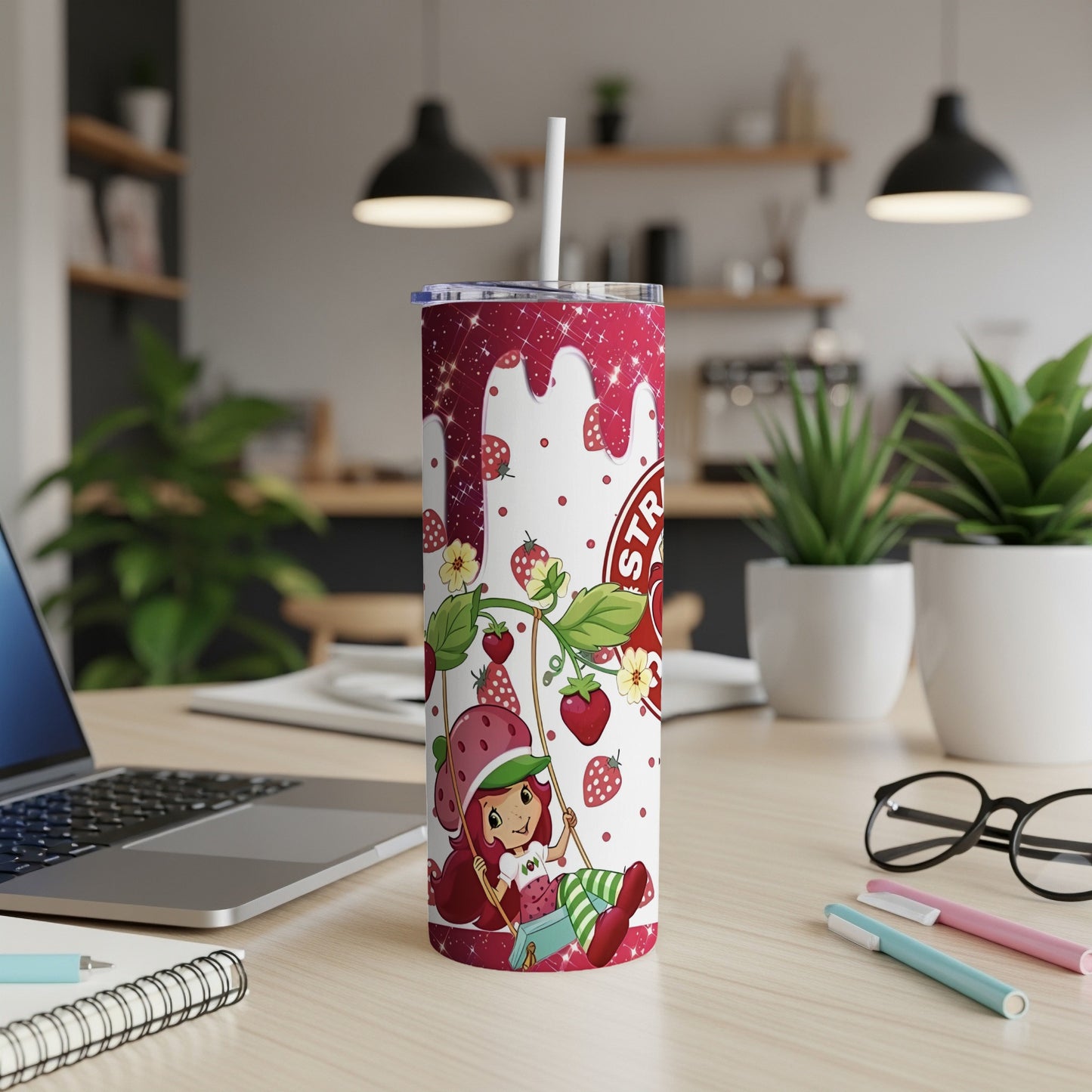 Strawberry Shortcake tumbler with straw on a desk.