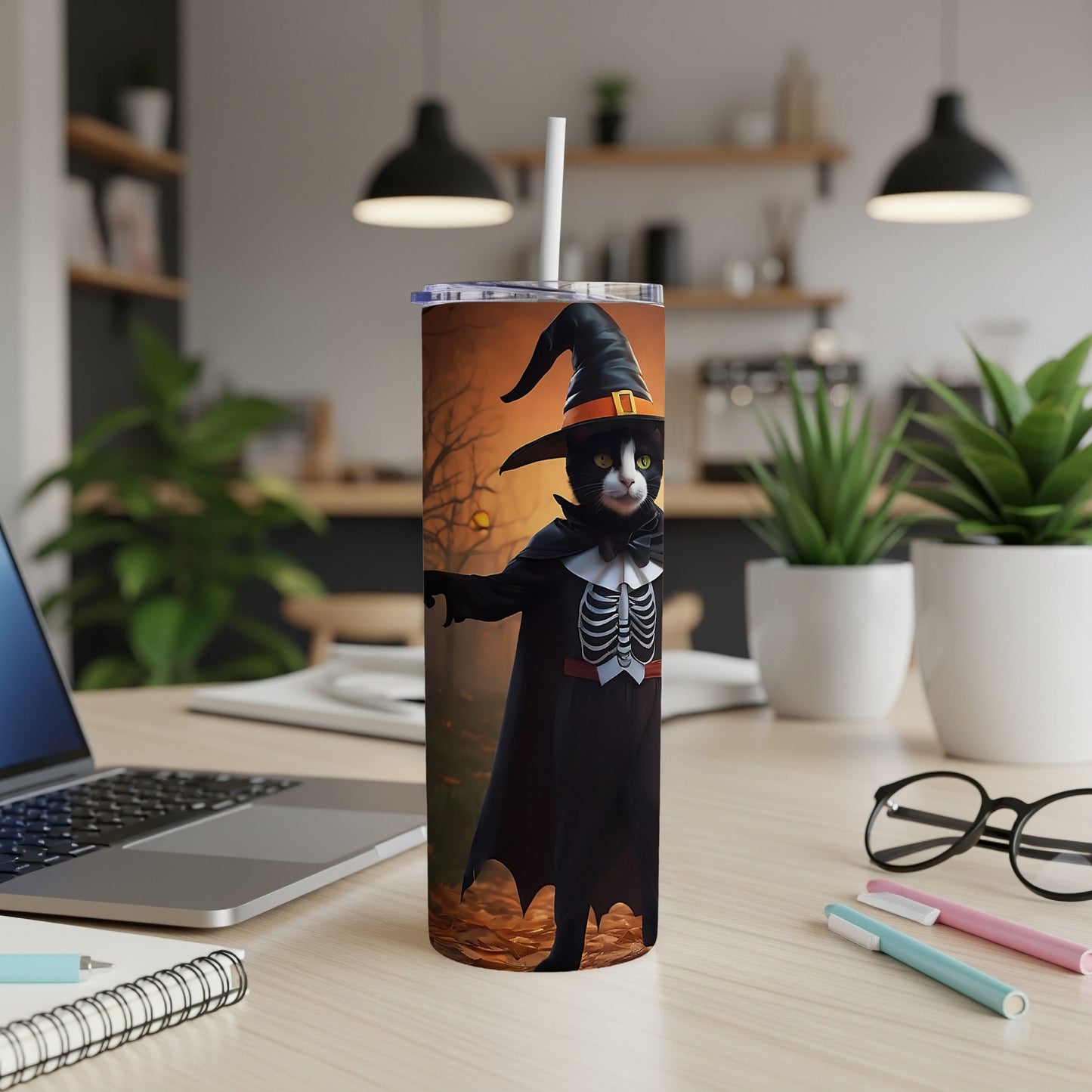 Black cat wearing a witch hat and skeleton costume on a Halloween-themed tumbler.