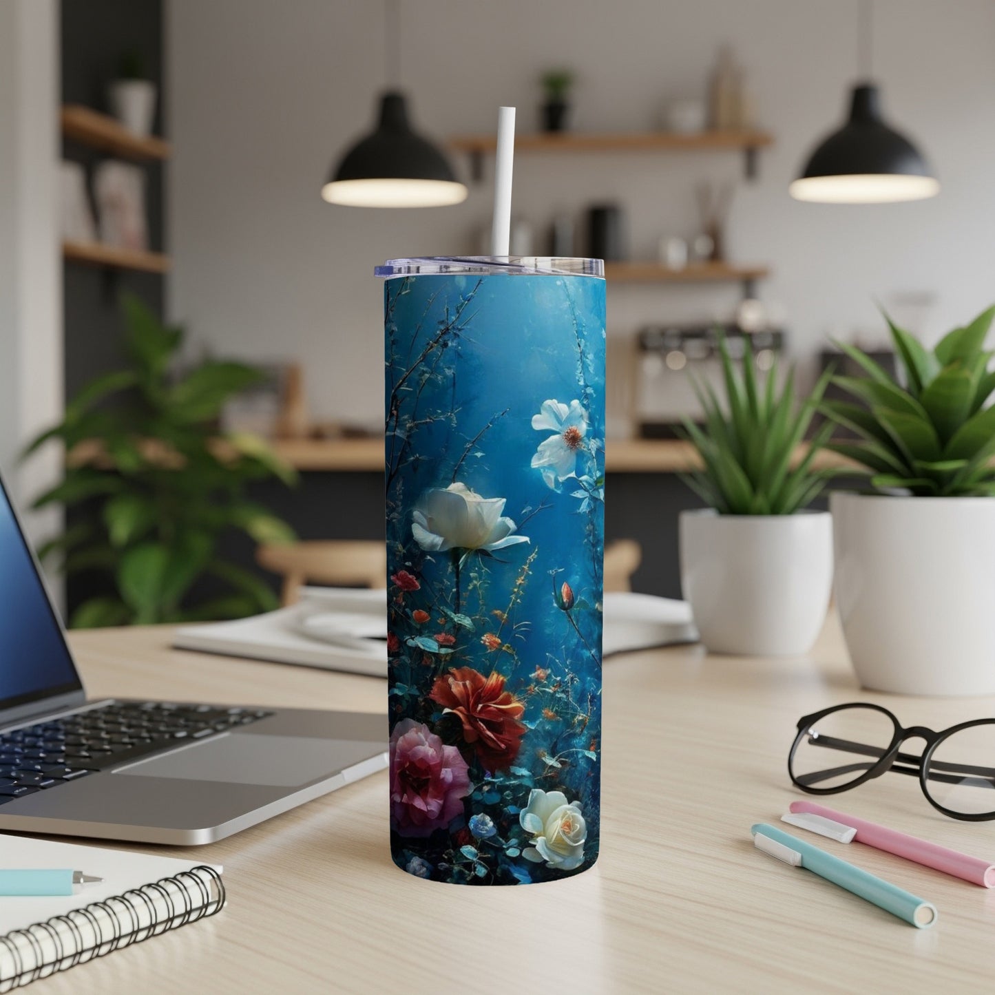 Blue floral tumbler with white straw on a desk.