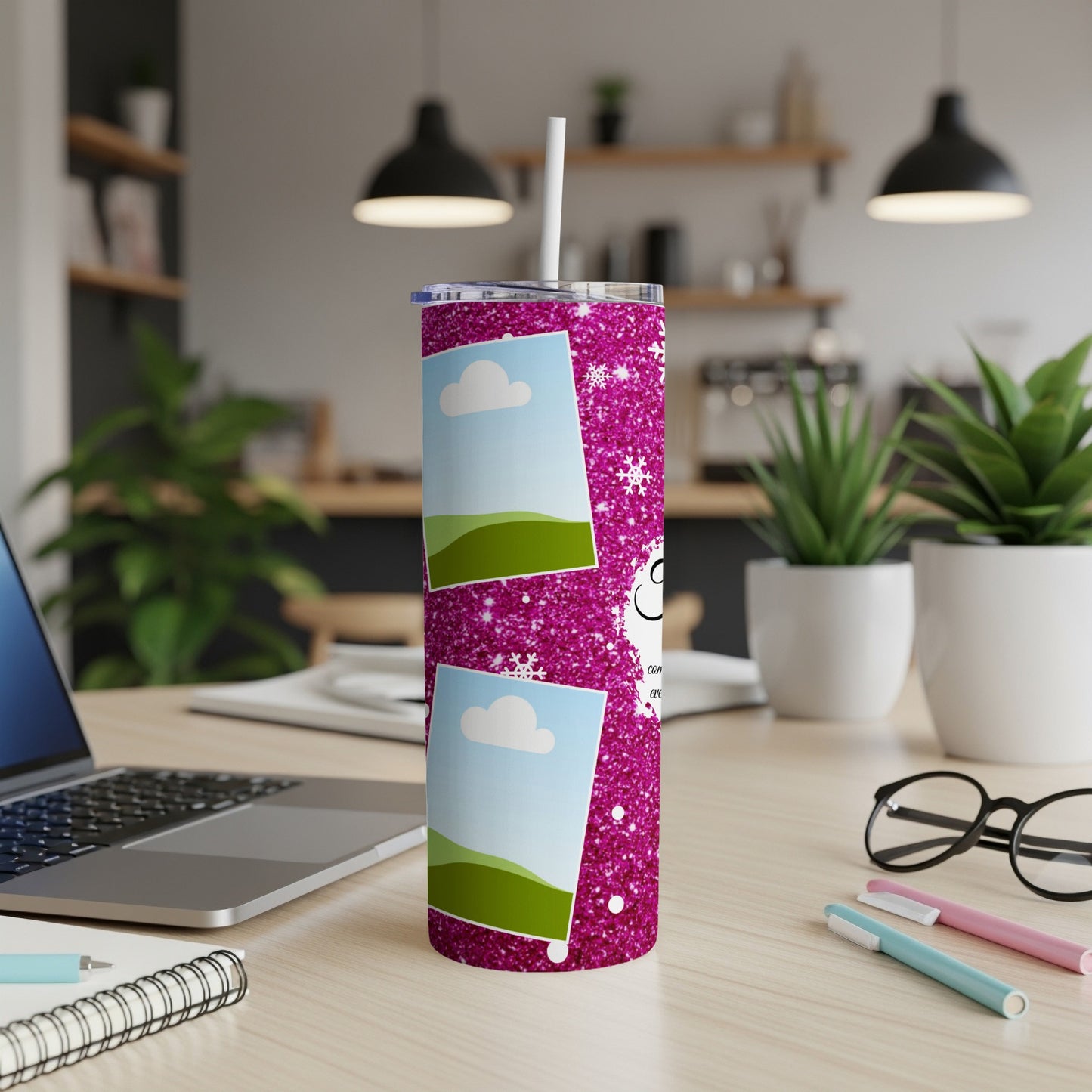Pink glitter tumbler with photo frames and snowflakes, sitting on a desk.