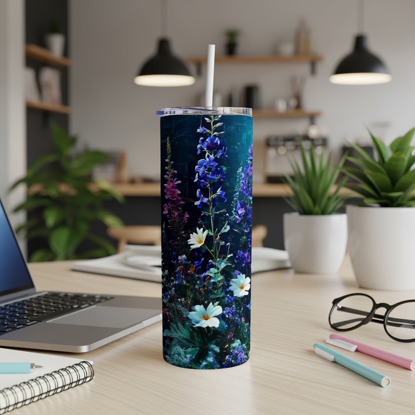 Floral pattern on a dark blue skinny tumbler with a white straw.