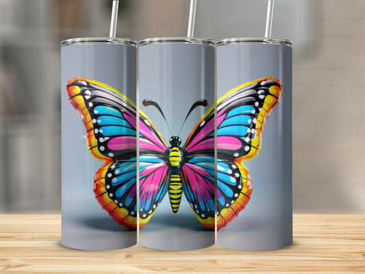 Colorful butterfly tumbler with straws on a gray background.