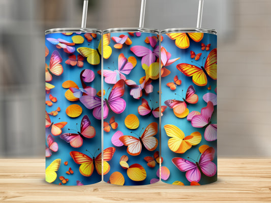 Three tumblers with colorful butterfly designs on a wooden surface.