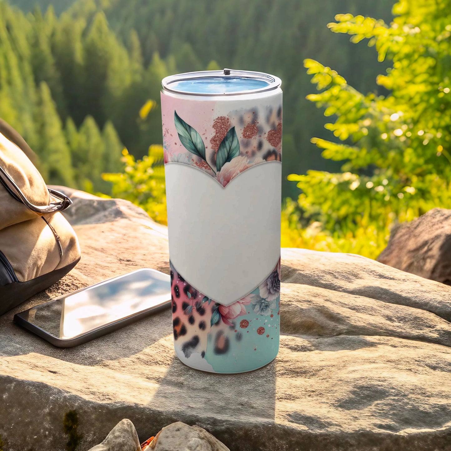Tumbler with floral and leopard print heart design on a rocky outdoor surface.