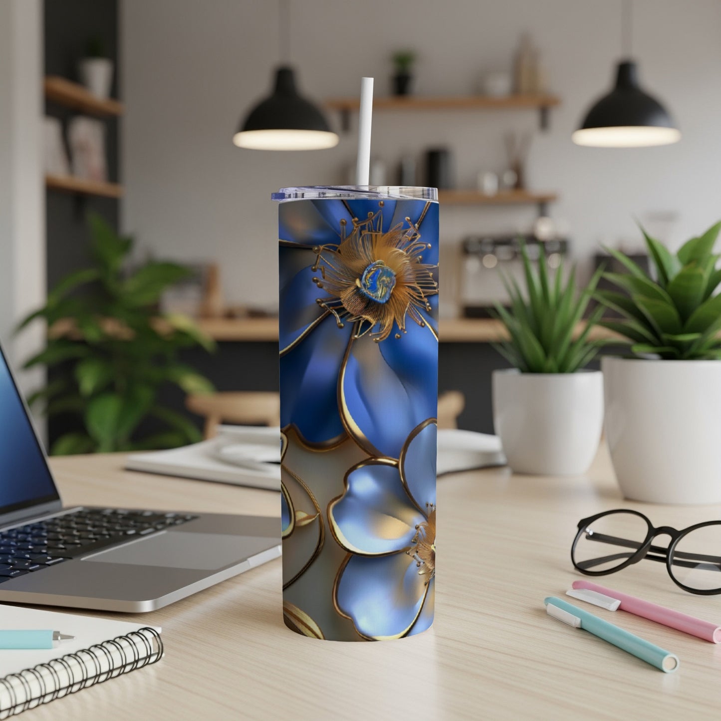 Blue floral tumbler with a white straw on a desk.
