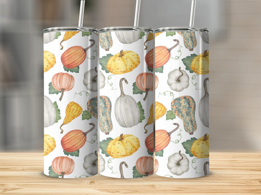 Pumpkin and gourd pattern on three white tumblers with straws.