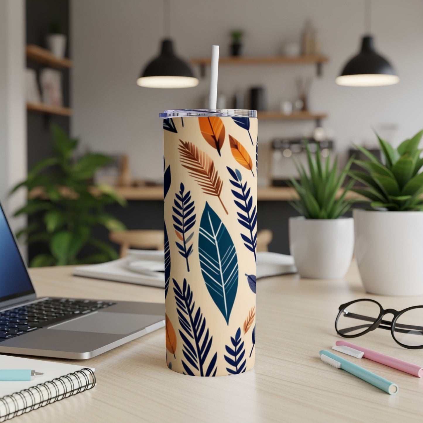 Tan tumbler with blue and orange feather pattern, white straw.
