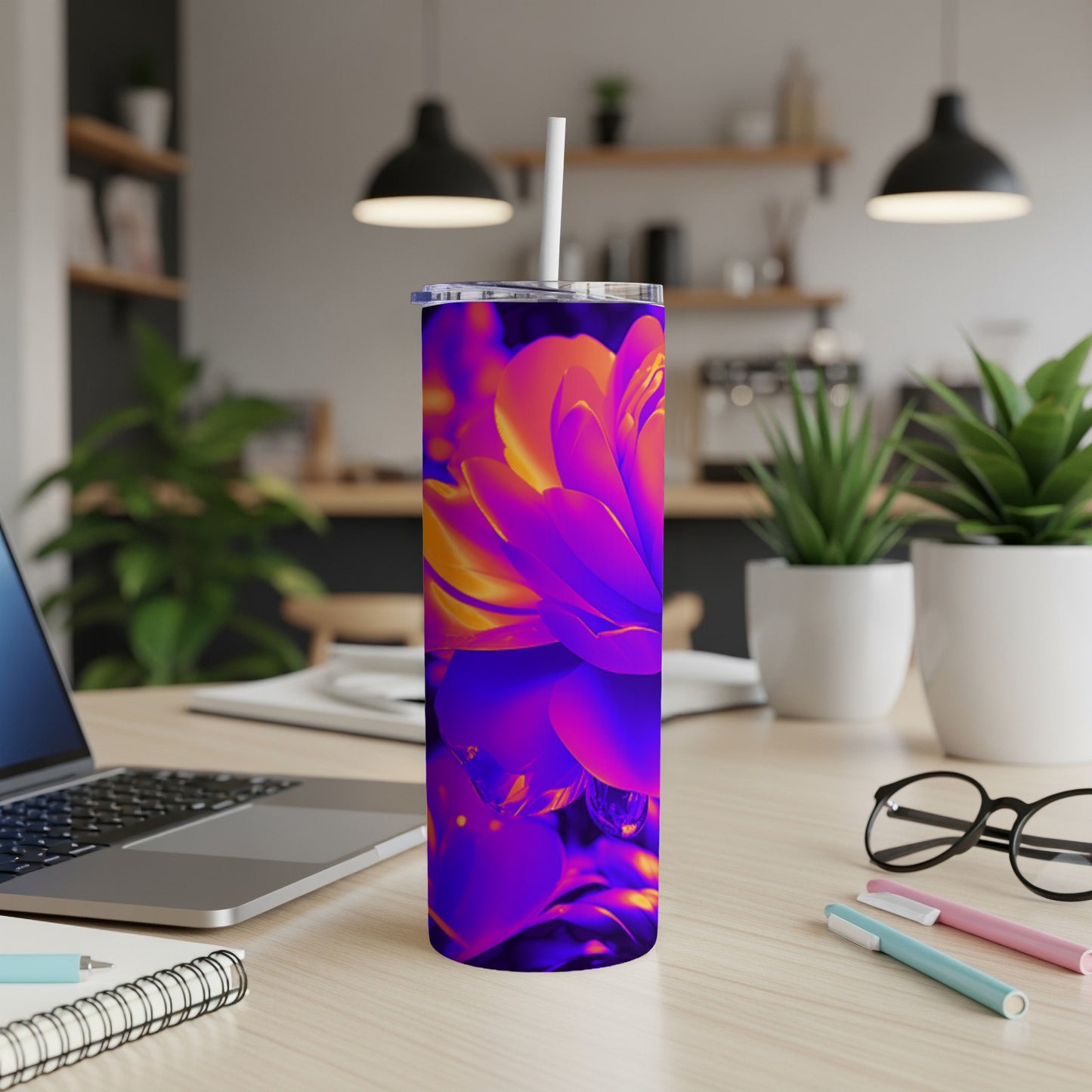 Tall, iridescent tumbler with vibrant floral design on a wooden desk.