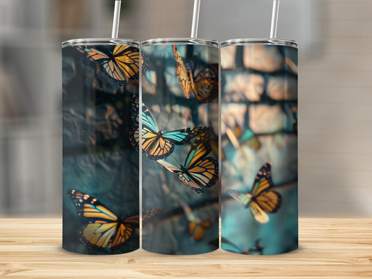 Three tumblers with colorful butterfly designs against a blurred background.
