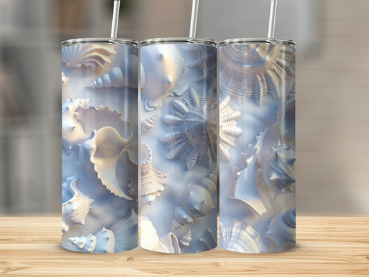 Three tumblers with a seashell and pearl design on a wooden surface.