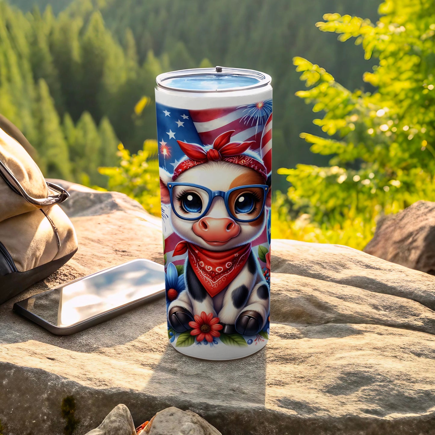 Cow tumbler with American flag bandana and glasses on a rock.