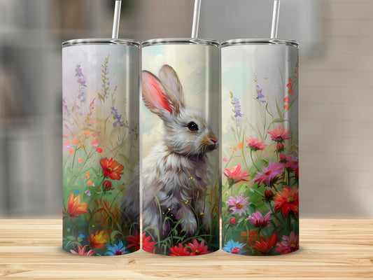 White bunny surrounded by colorful spring flowers on a floral tumbler.