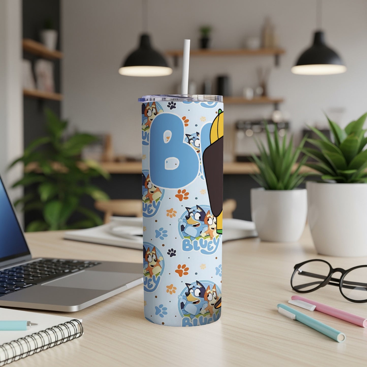 Bluey characters on a blue patterned tumbler with a white straw.