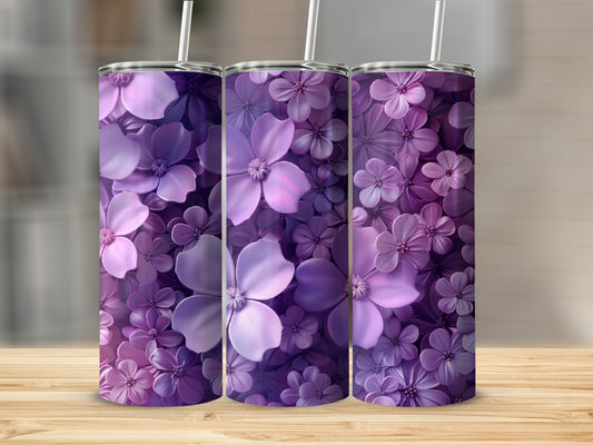 Three purple floral tumblers with straws on a wooden surface.