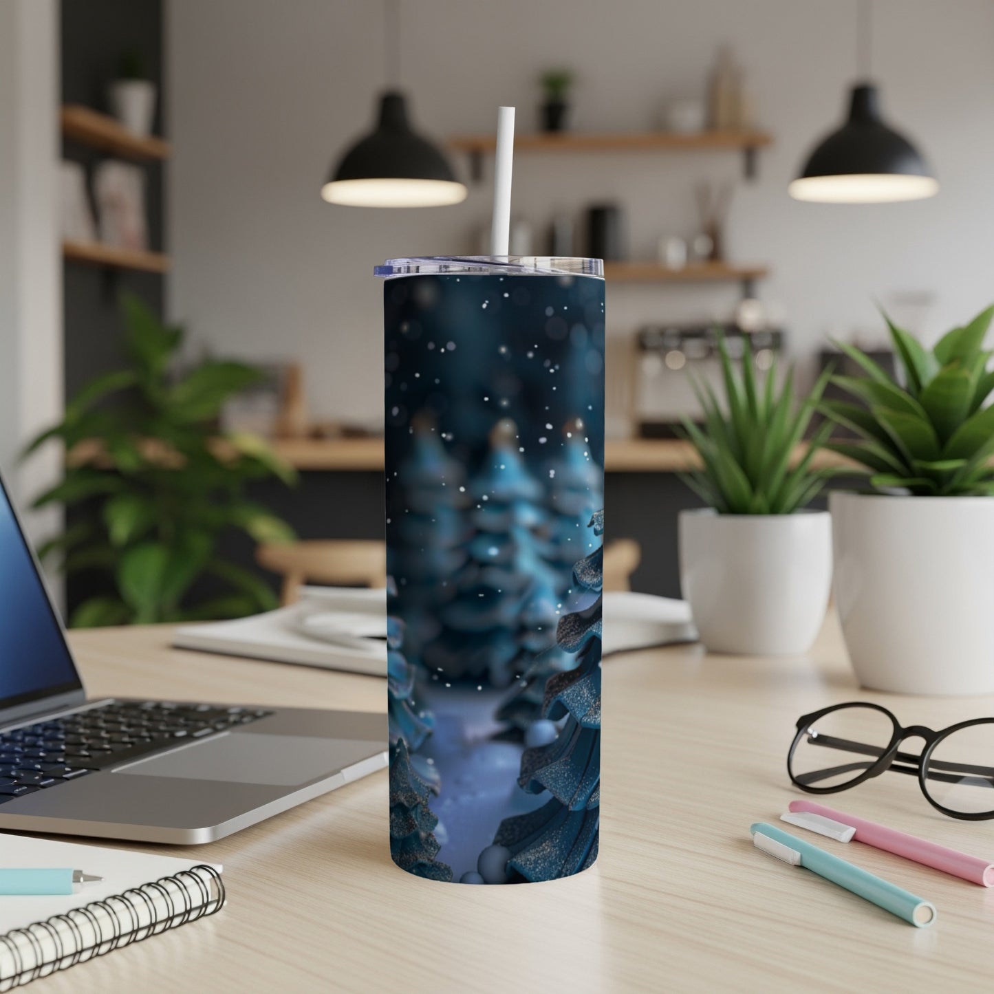 Blue glittery Christmas trees on a white tumbler with a straw.