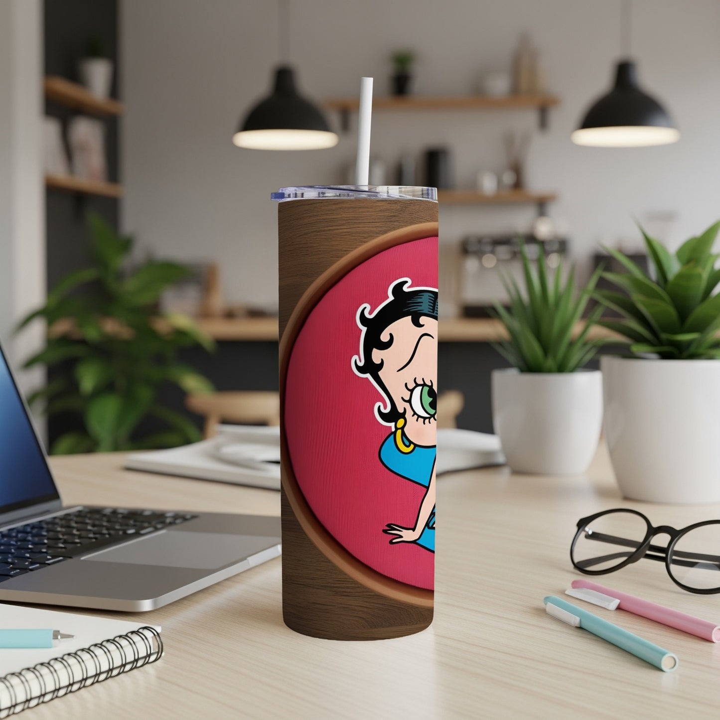 Betty Boop tumbler with straw on a desk.