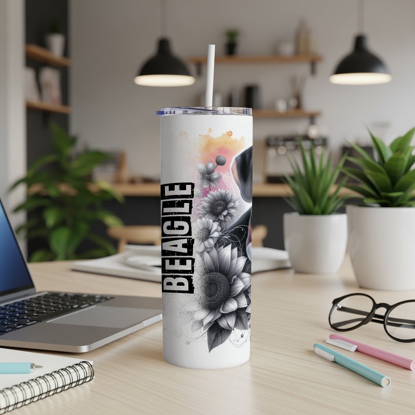 Beagle tumbler with floral design and straw on a desk.