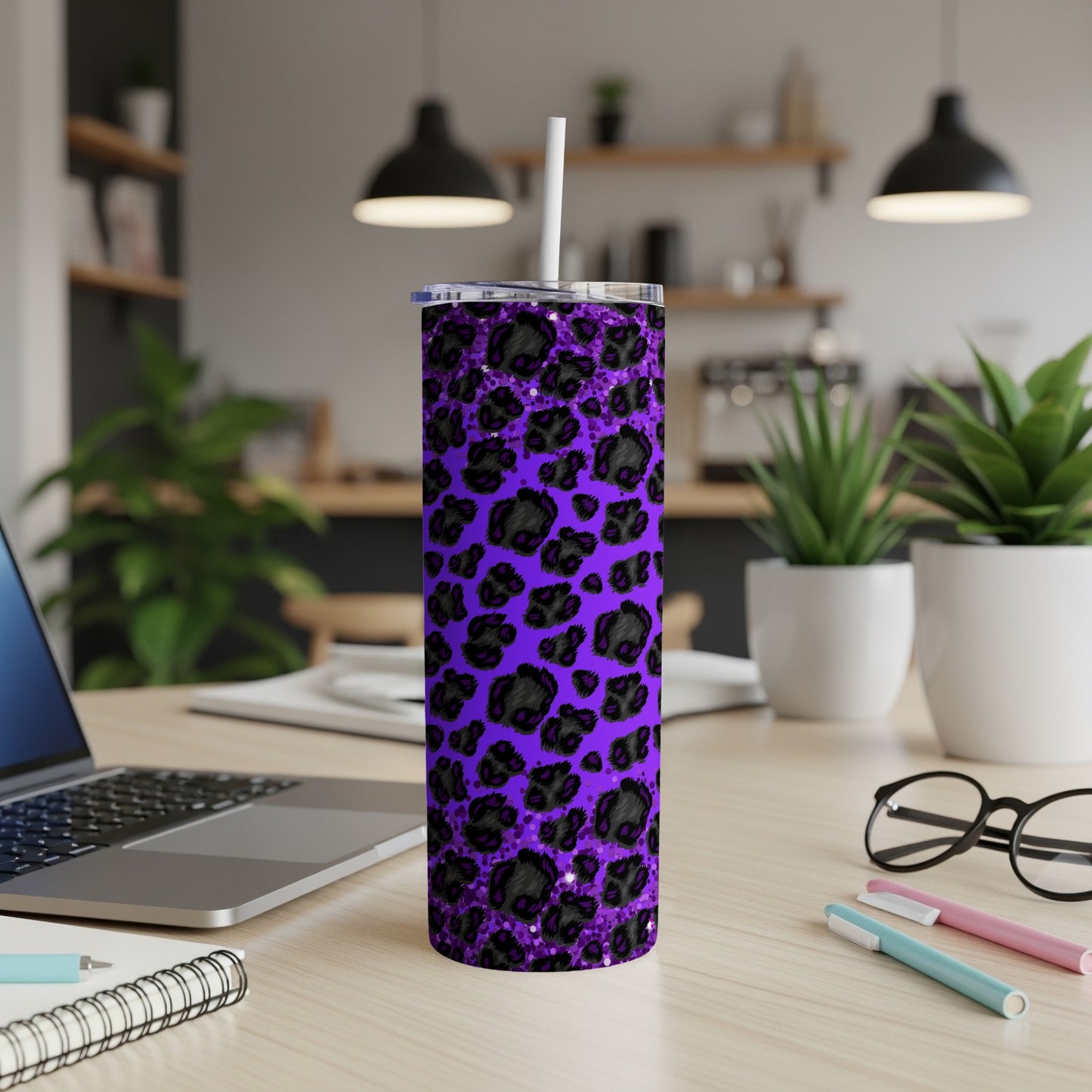 Purple leopard print skinny tumbler with white straw on a desk.