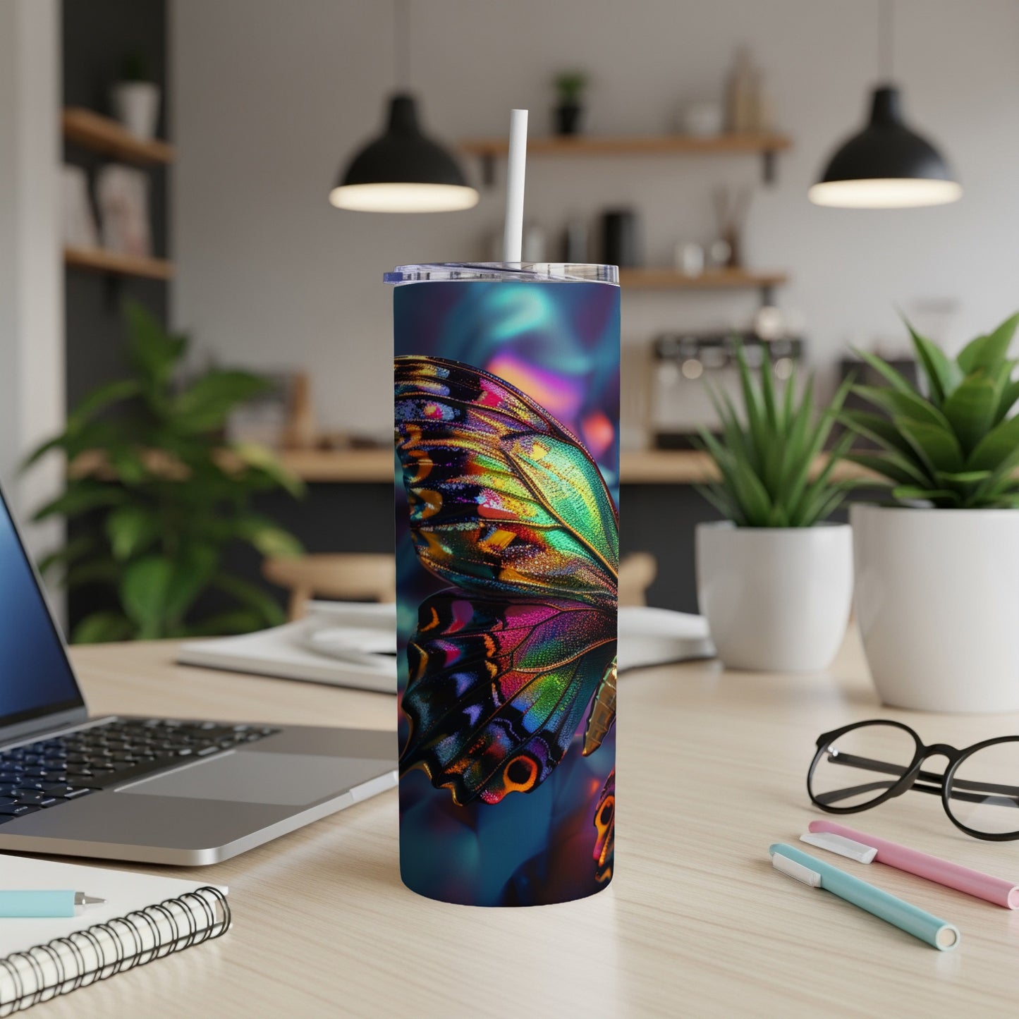 Colorful butterfly wing design on a skinny tumbler with a straw.